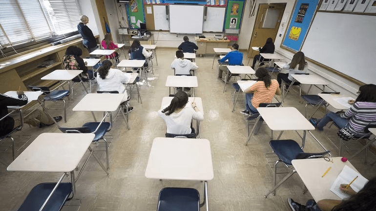 Dispersione scolastica, una classe con diversi banchi vuoti vista dall'alto