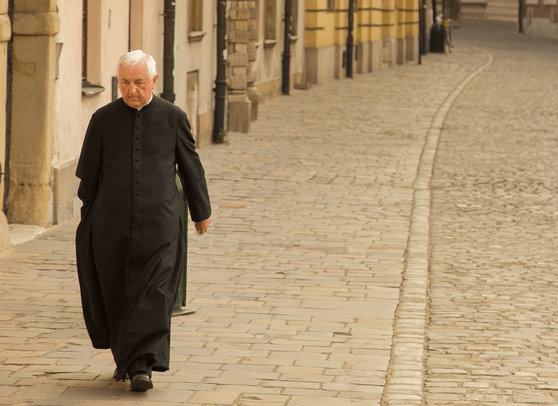 Fare il prete è un lavoro? Un religioso anziano cammina per strada, da solo