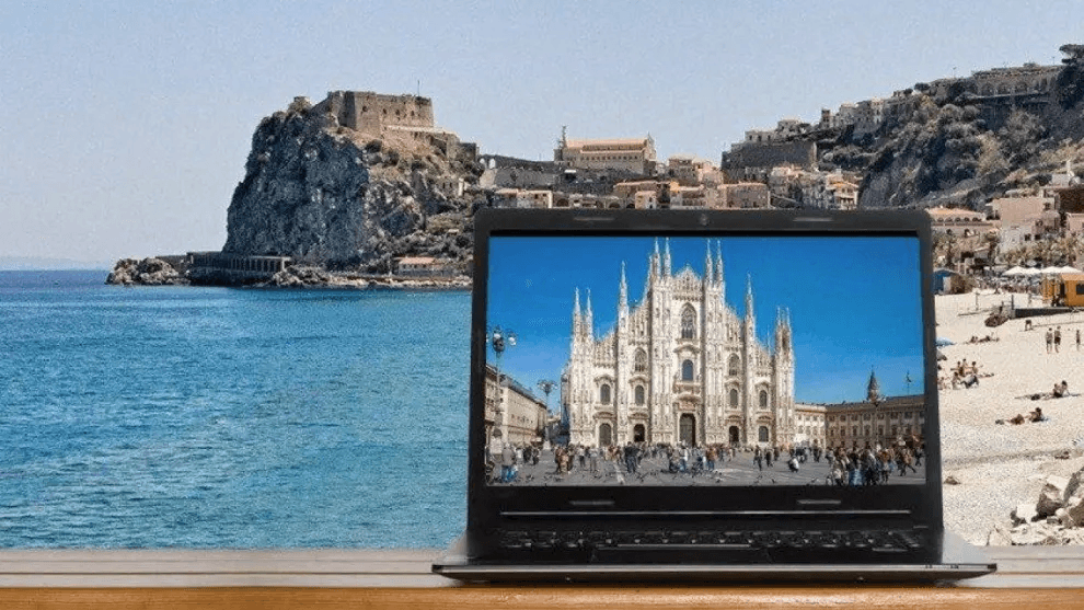 South Working e salari da Nord a Sud: un portatile su una località marina con il duomo di Milano come sfondo del desktop