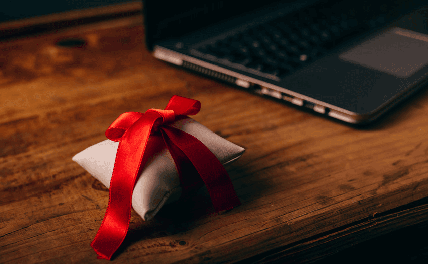 Welfare e benefit aziendali: un regalo su una scrivania da lavoro, accanto a un portatile