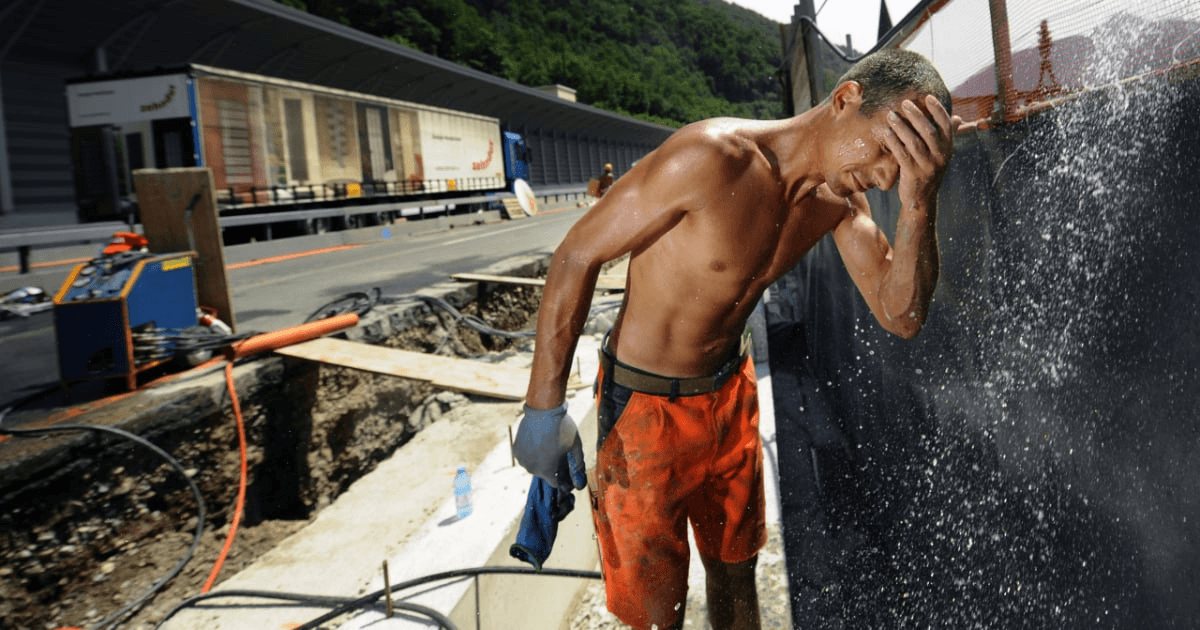 Lavoratori, fa troppo caldo: un operaio si rinfresca in un cantiere