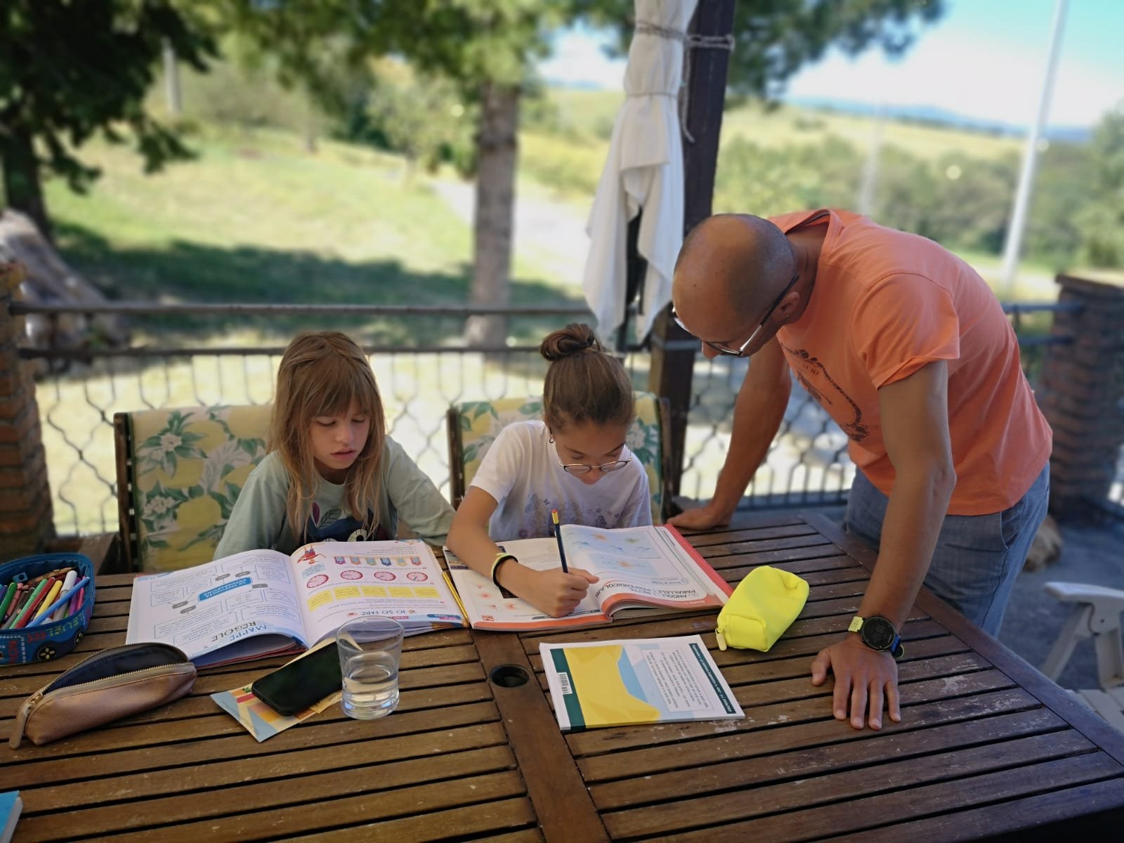 Compiti delle vacanze svolti da due bambine e da un adulto