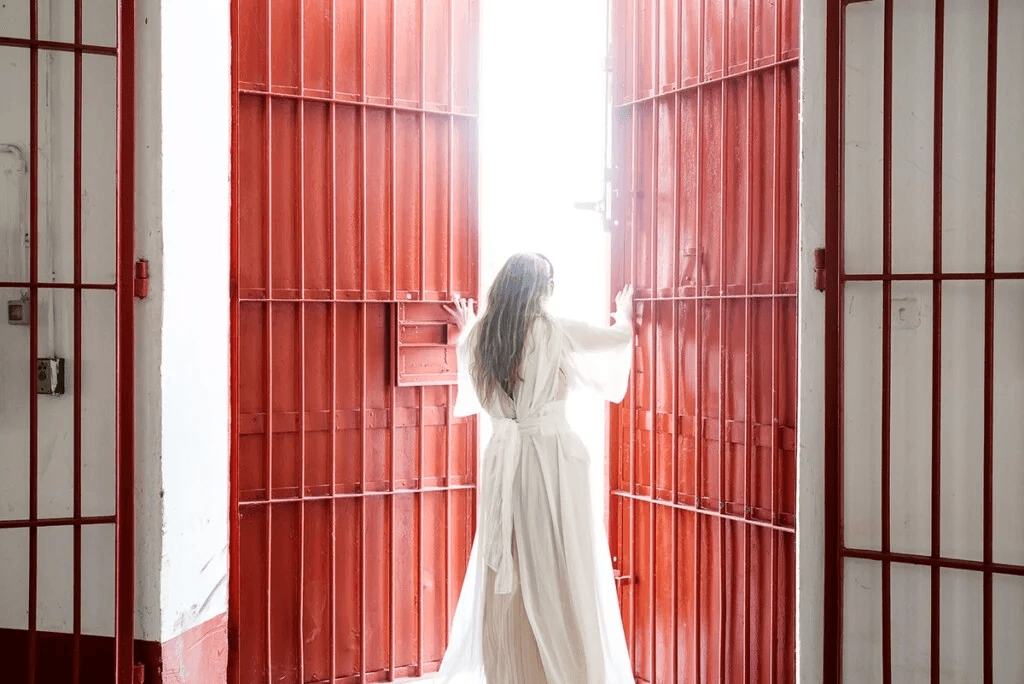 Open day in carcere, una donna vestita di bianco apre una porta a sbarre