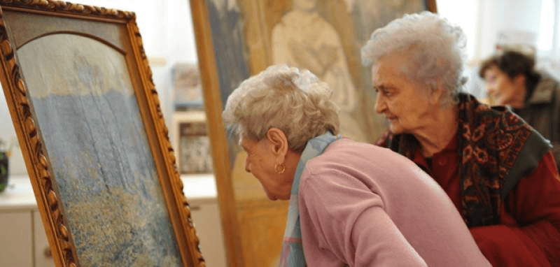 L'accessibilità nei musei: due donne anziane guardano un dipinto, incuriosite