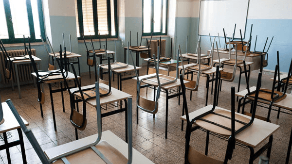 Dimensionamento scolastico e i suoi effetti: un'aula con le sedie rovesciate sui banchi, a riposo