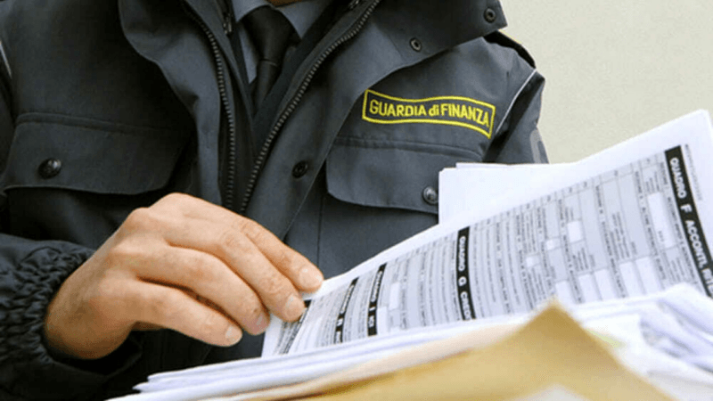 False fatturazioni, un agente della Guardia di Finanza controlla dei documenti