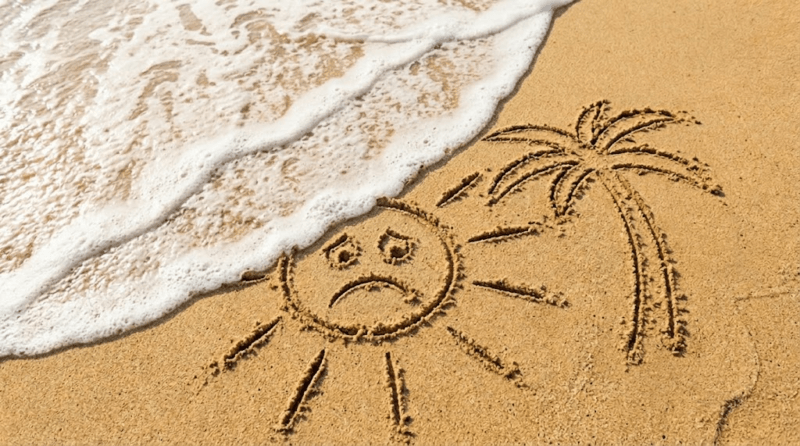 Ferie finite: ma ci siamo davvero riposati? Un sole disegnato sulla sabbia cancellato da un'onda