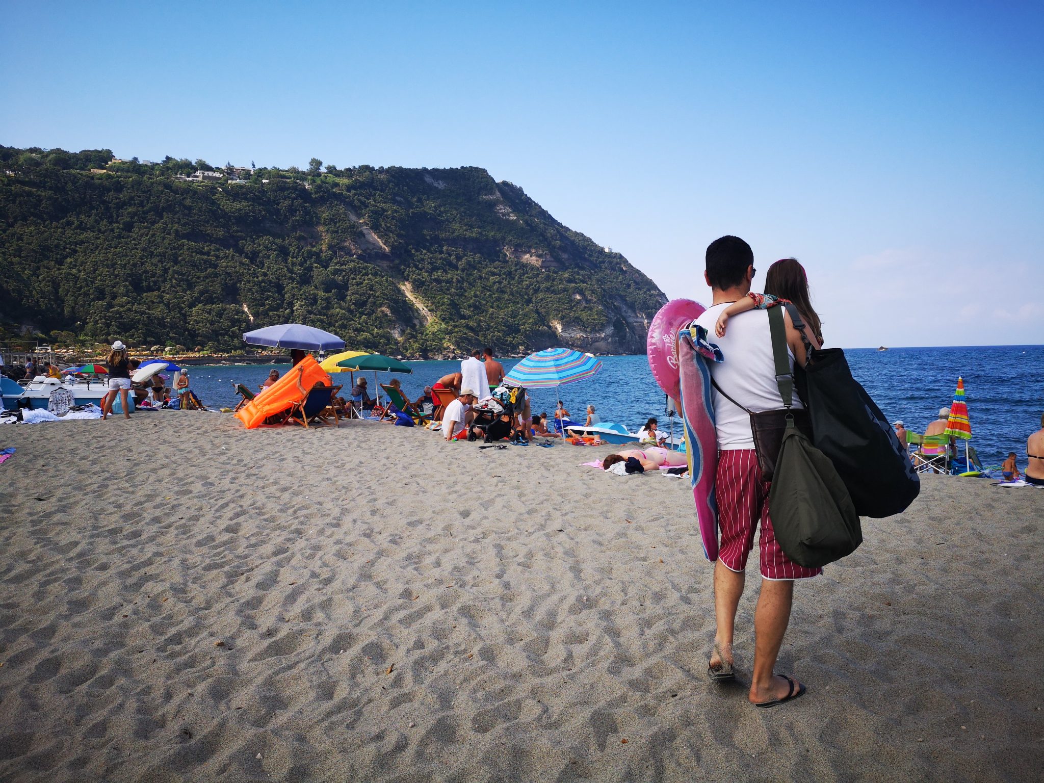 L'estate dei genitori: un papà sulla spiaggia con la figlia in braccio