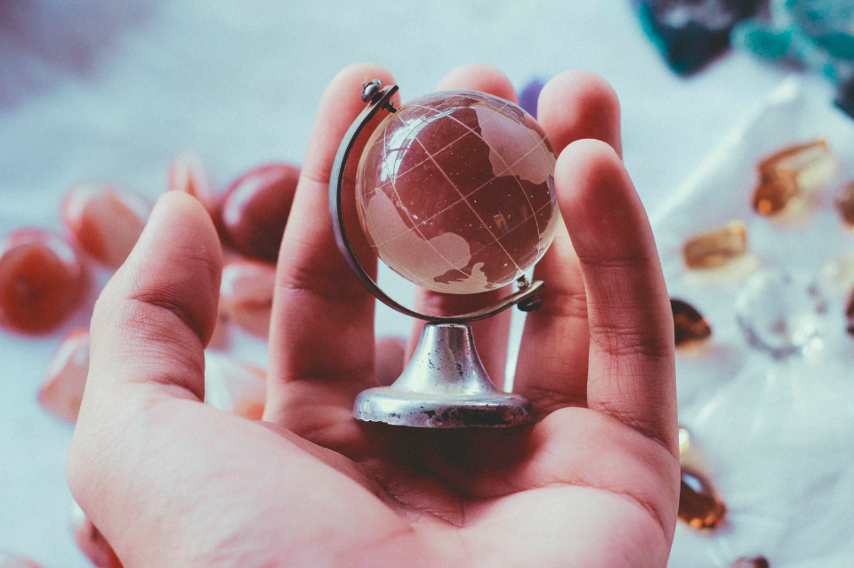 Lavoro in provincia: un globo in palmo di mano, come l'internazionalizzazione che potrebbe spingere sempre più verso il lavoro decentralizzato.