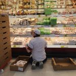 Uno dei lavoratori dei supermercati mentre rifornisce uno scaffale.