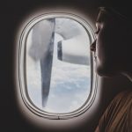 Una delle donne expat guarda fuori dal finestrino dell'aereo.