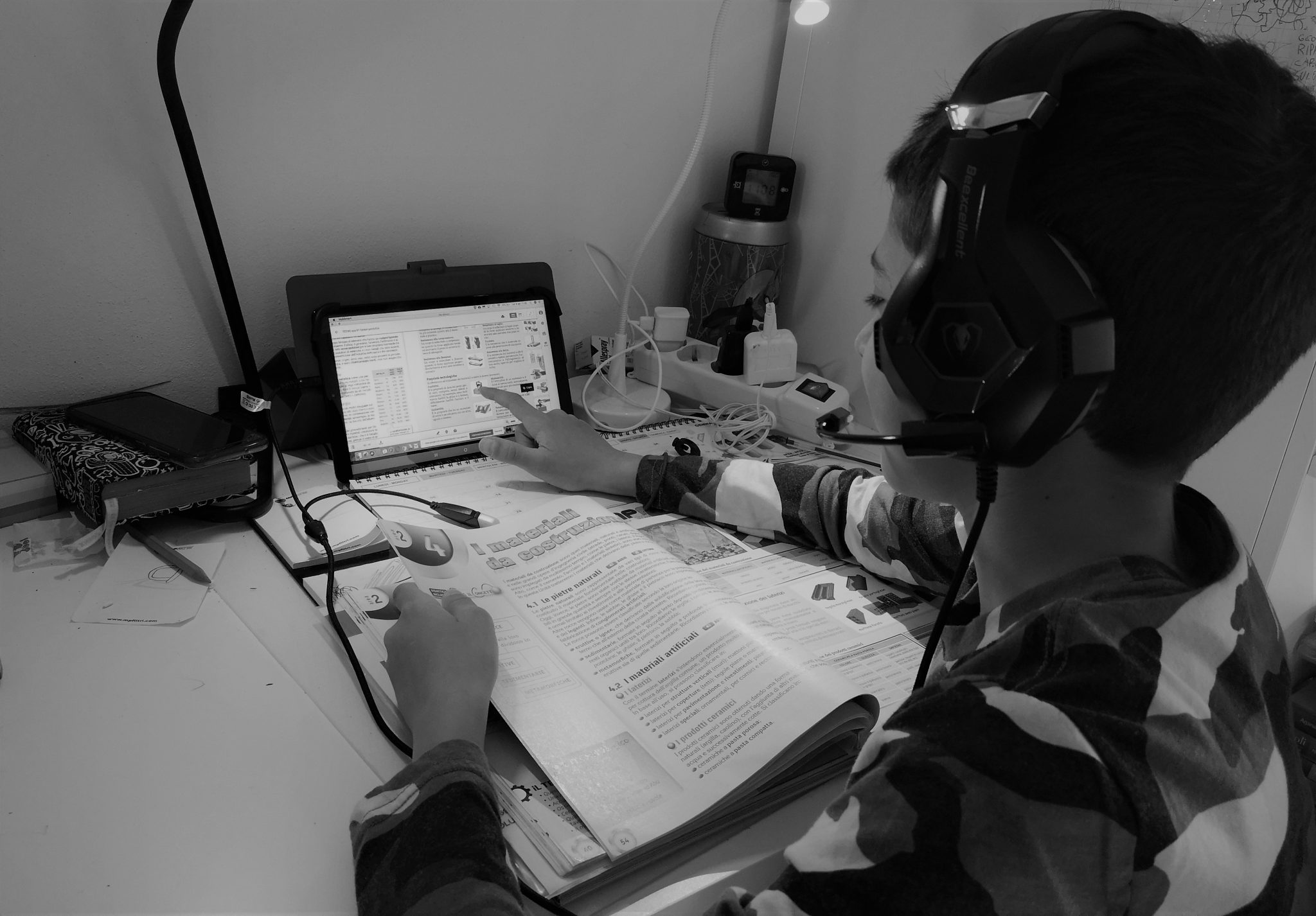 Tutti promossi gli studenti italiani costretti alla didattica a distanza; come quello in foto, che studia da libro e tablet.