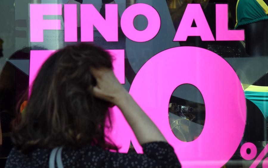 Saldi invernali 2021: una donna incerta davanti a una vetrina