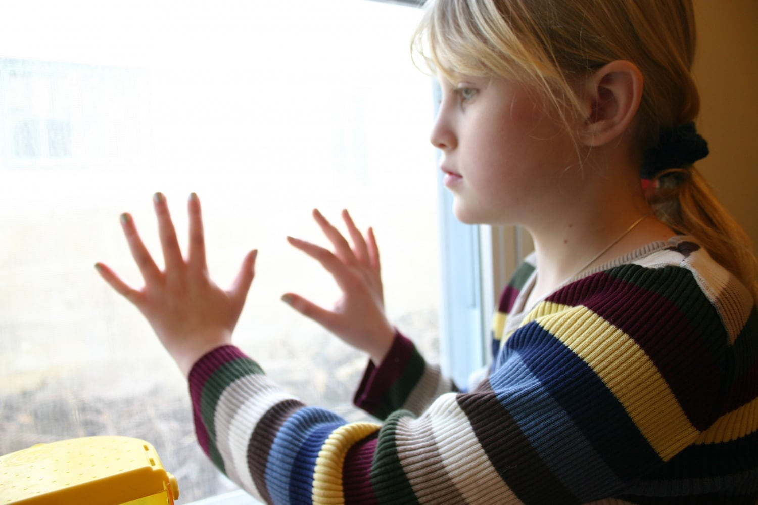 Segregati nelle RSD: una ragazza con autismo guarda l'esterno da dietro una finestra.