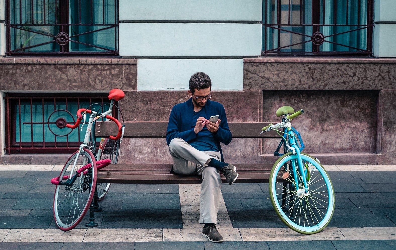 Tempo di lettura degli articoli online: un lettore distratto su una panchina legge dal suo smartphone.