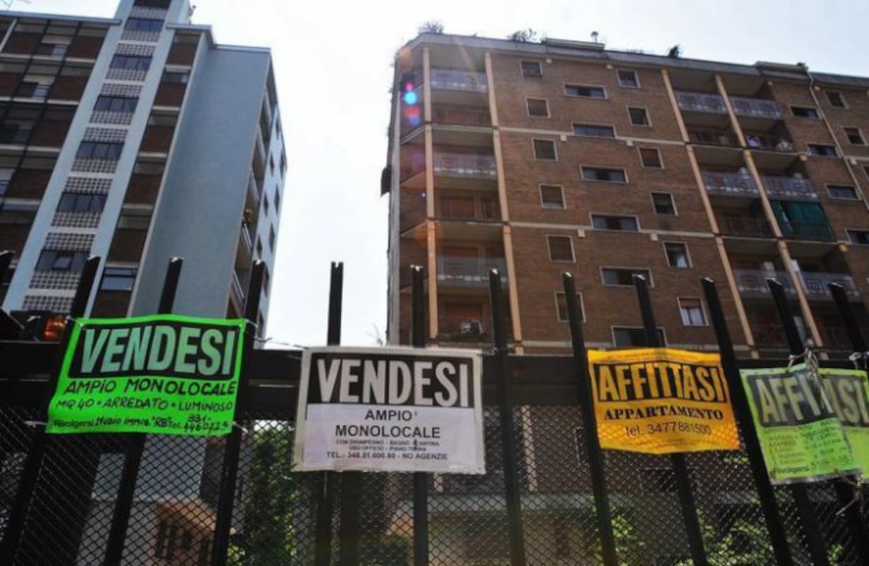Costo delle abitazioni a Milano: cartelli vendesi e affittasi sulla cancellata di dei condomini